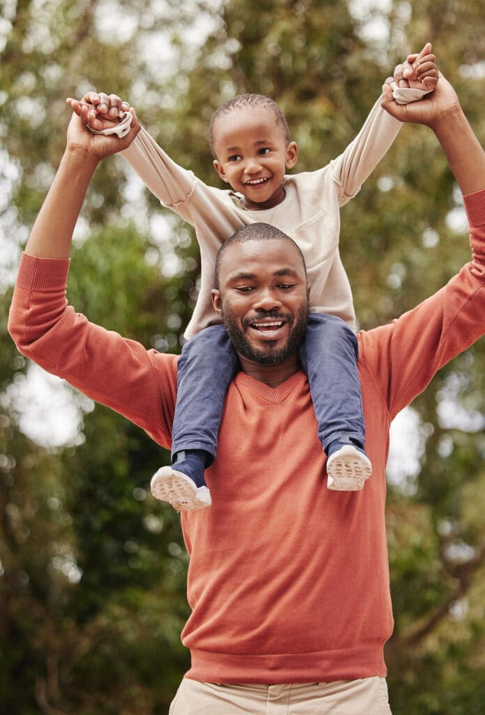 father holding son on shoulders